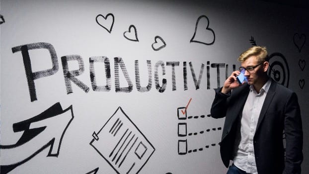 man holding smartphone looking at productivity wall decor