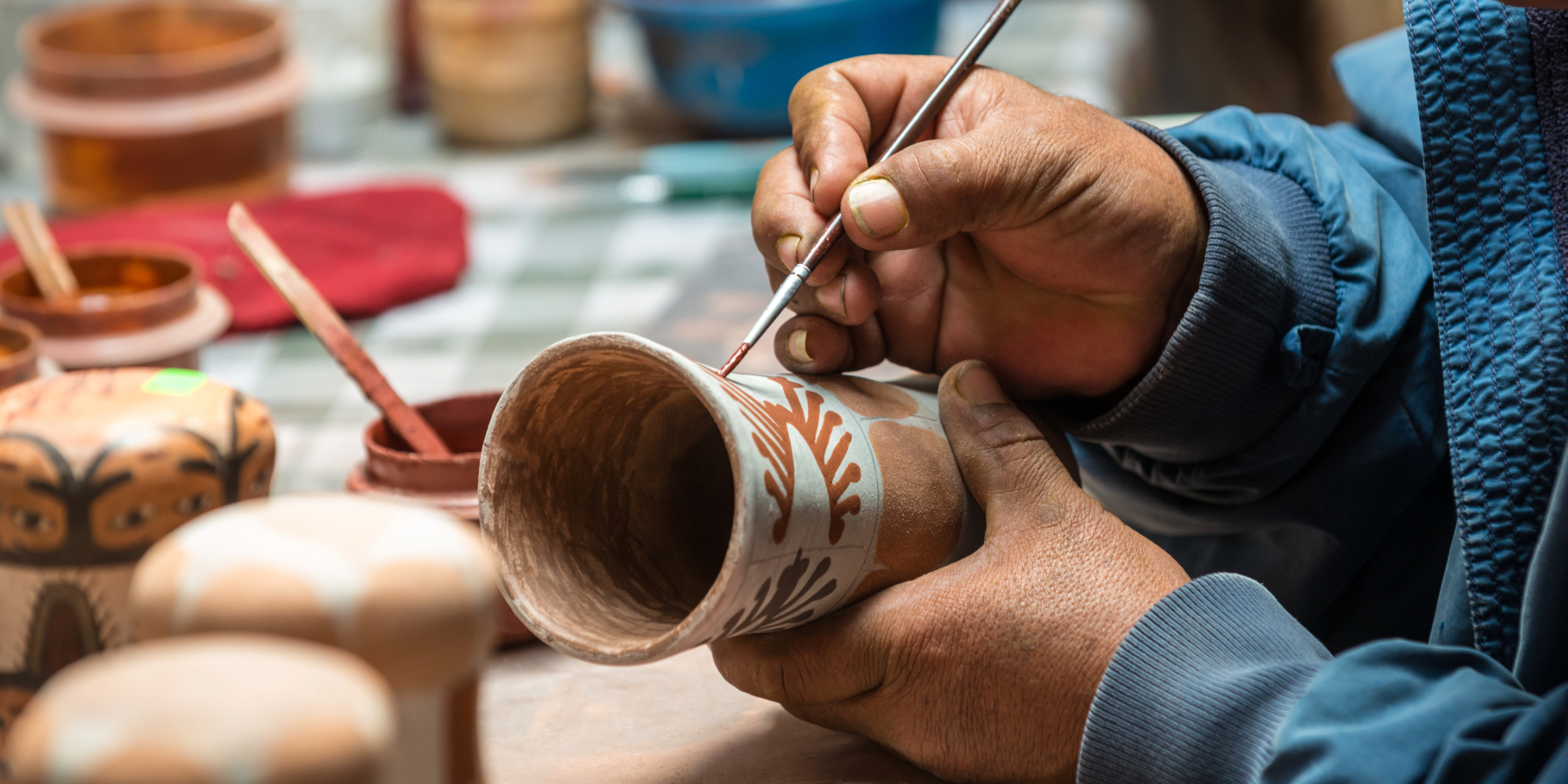 An image of an artisan hand-crafting a clay piece.